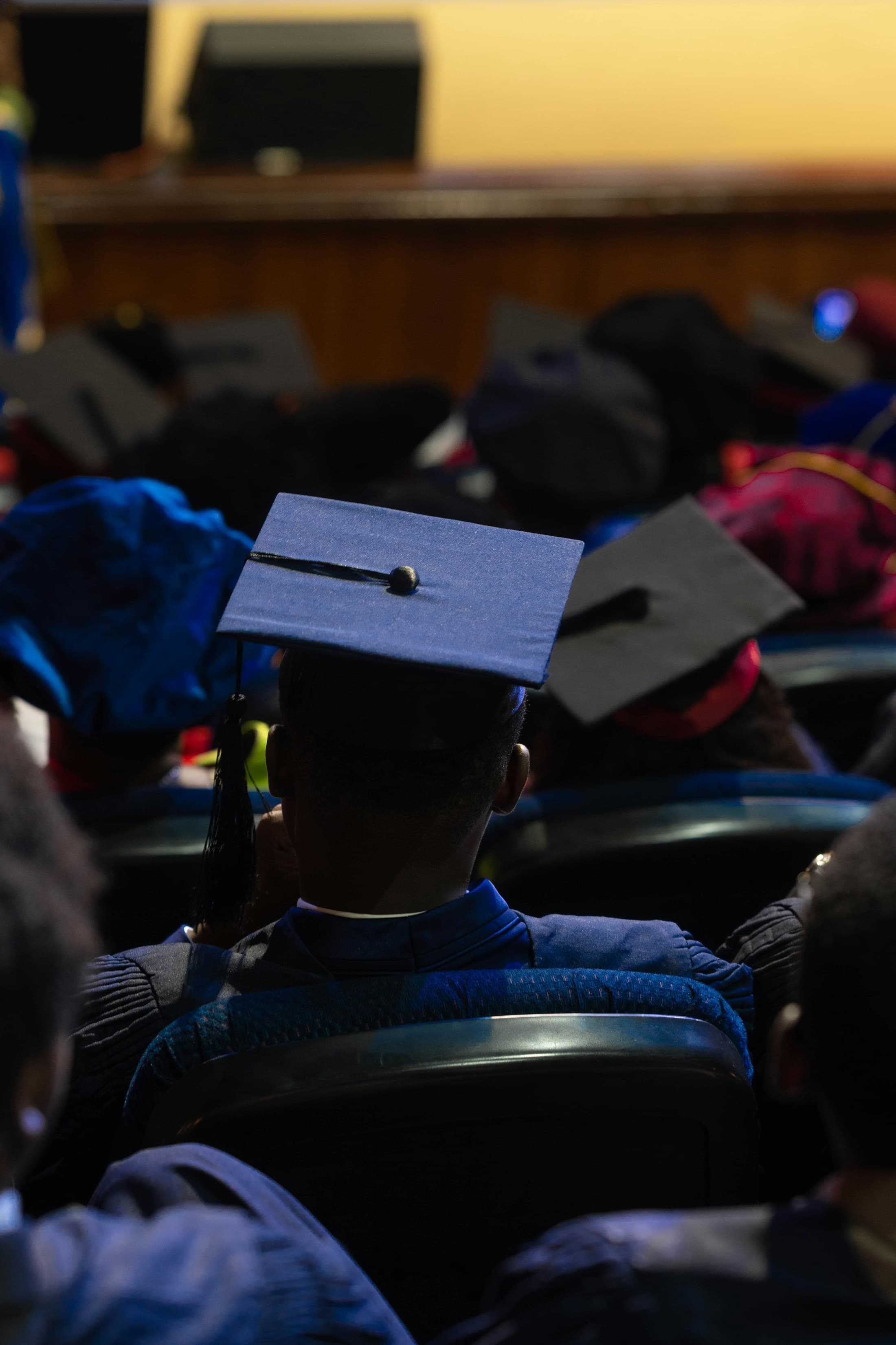 A graduate in a cap seated at a convocation ceremony