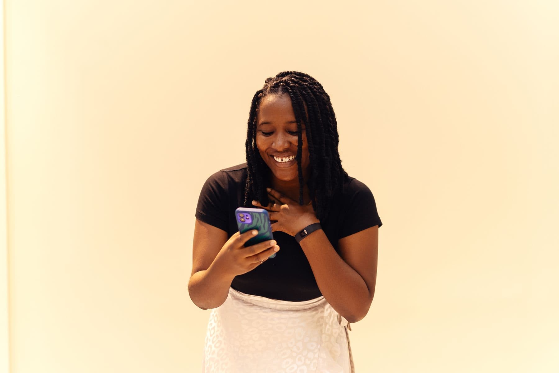 Young woman smiling at her phone as she creates a wish