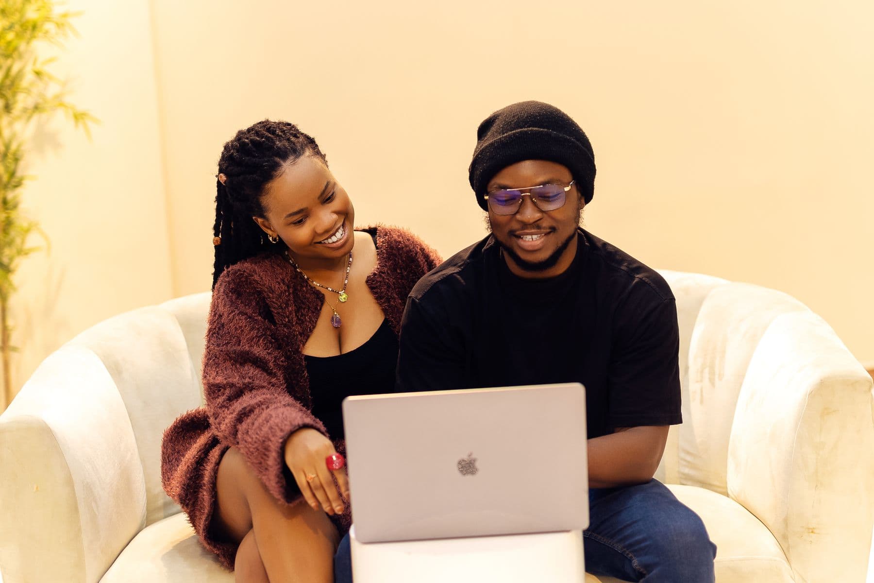 Two friends smiling at a laptop as contributions come in
